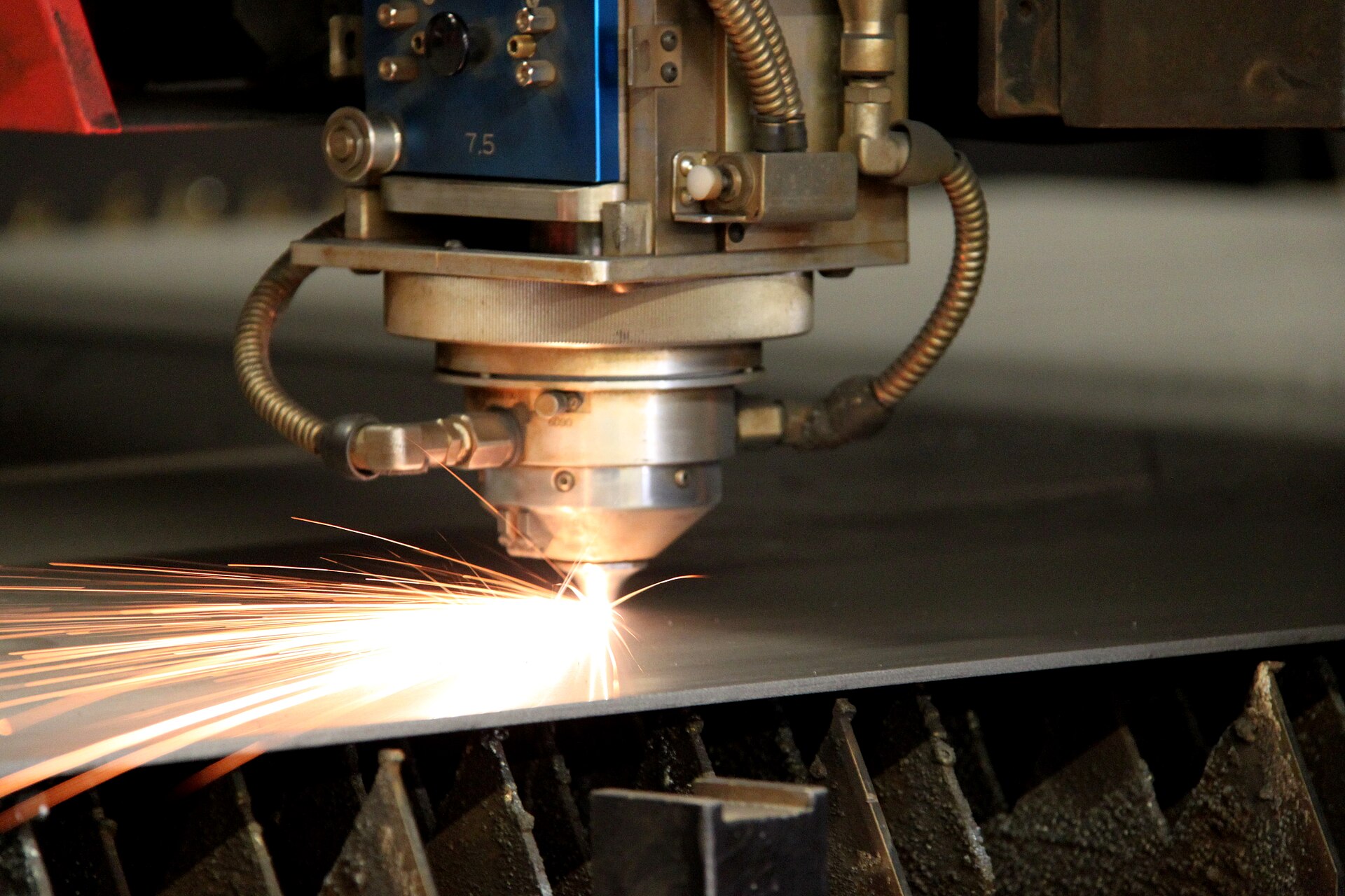 A fibre laser head cutting steel sheet, sparks flying